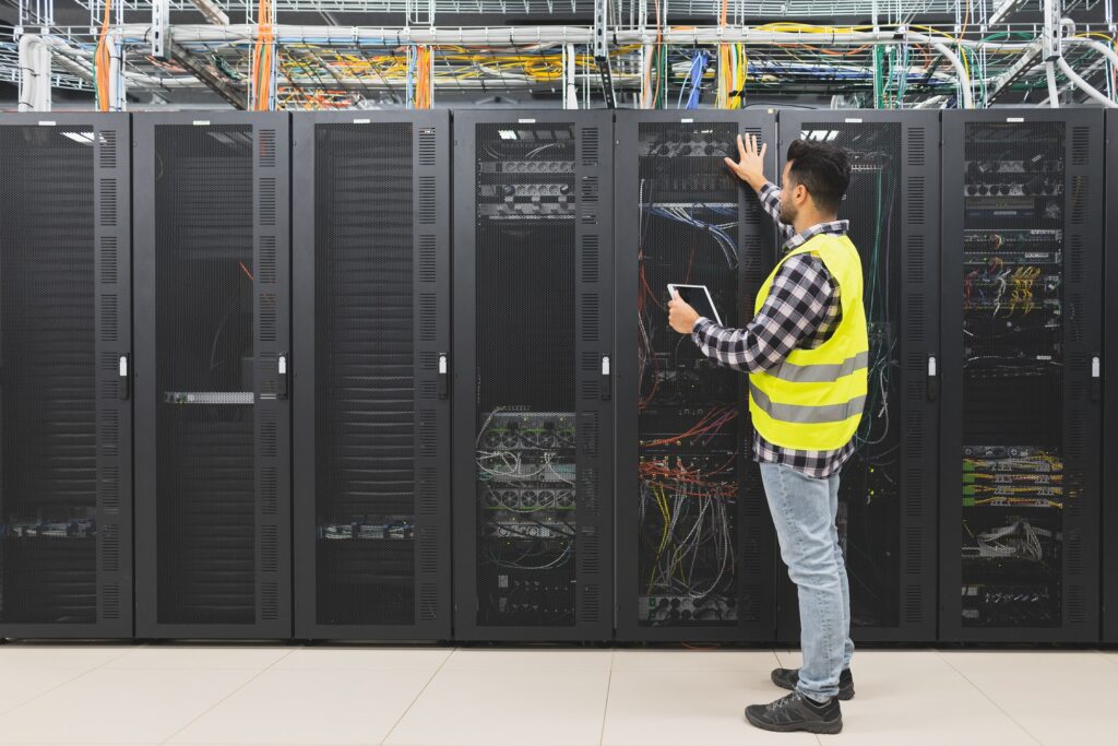 Male informatic engineer working inside server room database
